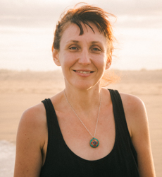 woman standing at the beach smiling