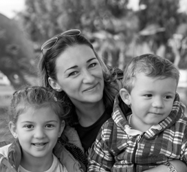 mother holding two young children smiling