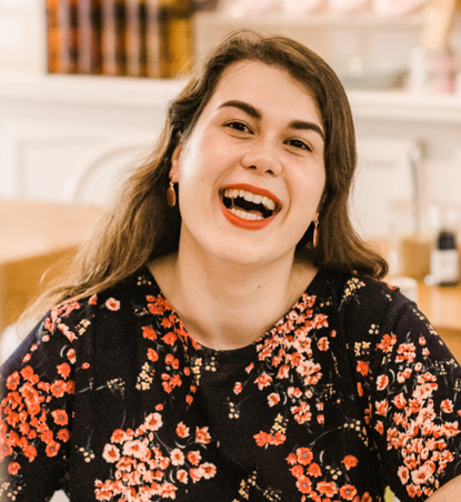 smiling woman wearing red lipstick and colourful shirt