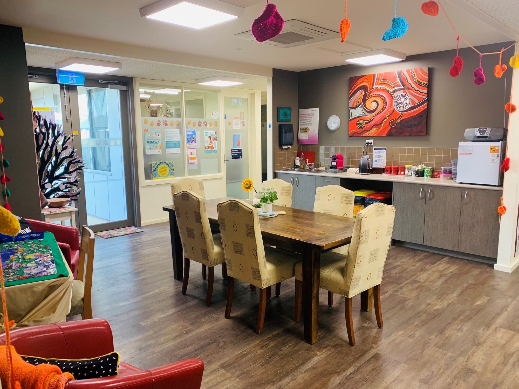 women in blue shirt and grey pants pick a book off a shelf
